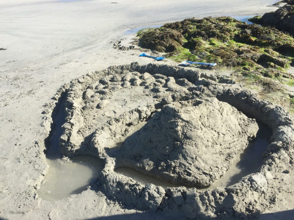 Picture of sandcastle up against rocks